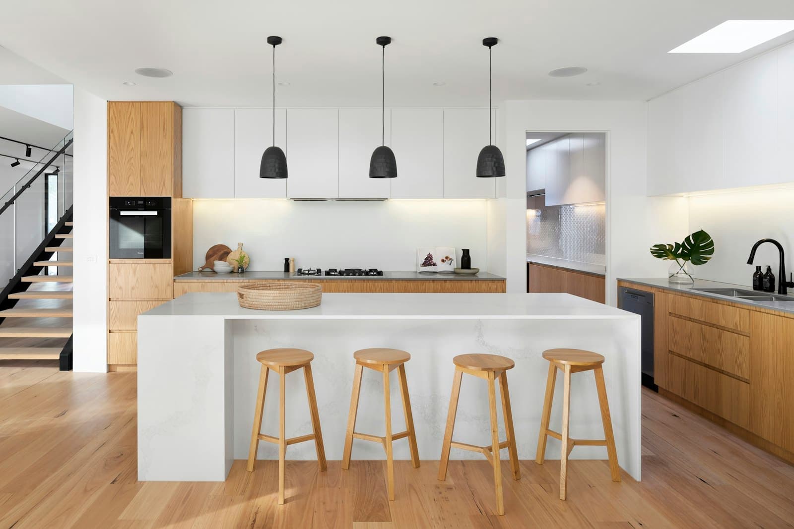 The kitchen, with an island, breakfast seating and a separate scullery beyond